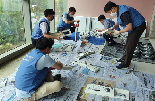 포스코O&M 임직원들이 업사이클링 세탁기를 조립하고 있는 모습. <포스코O&M 제공>